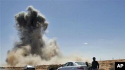 Smoke rises following an air strike by Libyan warplanes near a checkpoint close to the anti-Gadhafi rebels' checkpoint in the oil town of Ras Lanouf, eastern Libya, March 7, 2011