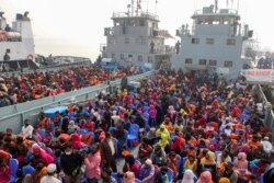 FILE - Rohingya refugees headed to the Bhasan Char island board navy vessels from the south eastern port city of Chattogram, Bangladesh, Feb. 15, 2021.