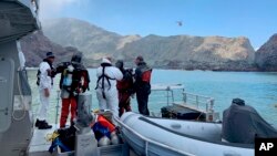 Para penyelam dari kepolisian bersiap melakukan pencarian korban di dalam air dekat Pulau Putih di lepas pantai Whakatane, Selandia Baru, 14 Desember 2019.