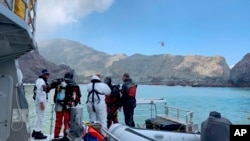 Police divers prepare to search the waters near White Island off the coast of Whakatane, New Zealand, Dec. 14, 2019.