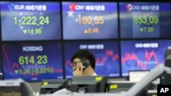 A currency trader talks on the phone at the foreign exchange dealing room of the KEB Hana Bank headquarters in Seoul, South Korea, March 14, 2017.