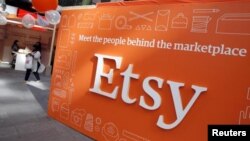 FILE - A sign advertising the online seller Etsy Inc. is seen outside the Nasdaq market site in Times Square, April 16, 2015.