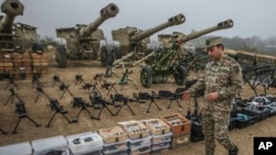 FILE - An Azerbaijani army officer shows weapons and equipment surrendered by Armenian forces in Nagorno-Karabakh displayed in Signag village, Azerbaijan, Oct. 1, 2023. 