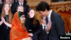 PM Kanada Justin Trudeau (kanan) memberikan hormat kepada warga Pakistan penerima anugerah Nobel Perdamaian Malala Yousafzai seusai upacara pengungerahan kewarganegaraan kehormatan Kanada di Perpustakaan Parlemen Kanada di Ottawa, Ontario, Kanada, 12 April 2017. (REUTERS/Chris Wattie).