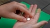 FILE - A patient prepares to take the first of two combination pills, mifepristone, for a medication abortion in Kansas City, Kansas, Oct. 12, 2022. On Nov. 19, 2024, a judge in Wyoming struck down an explicit prohibition on the use of medication to end pregnancy. 