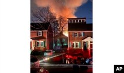 A home is seen exploding from a distance on Dec. 4, 2023, in the Bluemont neighborhood in Arlington County, Virginia, just outside the U.S. capital, Washington.