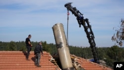 Israeli bomb squad police officers remove part of a missile fired by Yemen's Houthi rebels after it hit a house in the Israeli village of Mevo Beitar, near Jerusalem, on Jan. 14, 2025.