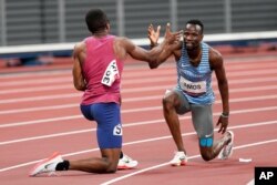 Isaiah Jewett, of the United States, and Nijel Amos, right, of Botswana, shake hands after falling in the men's 800-meter semifinal at the 2020 Summer Olympics, Aug. 1, 2021, in Tokyo.