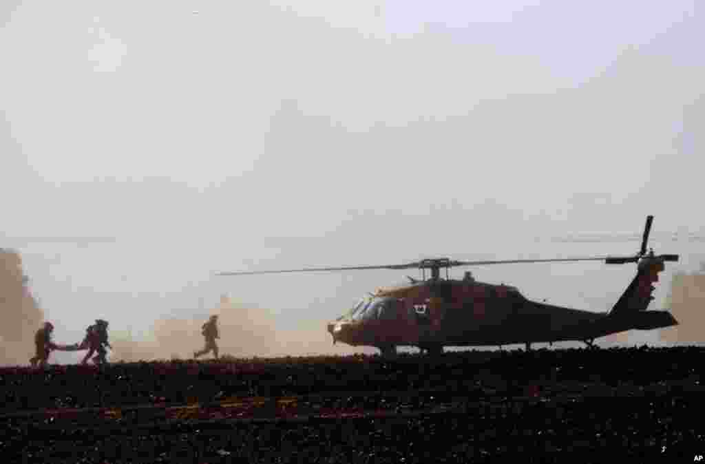 Israeli soldiers carry a wounded soldier to a helicopter near the Israel and Gaza border, July 24, 2014.