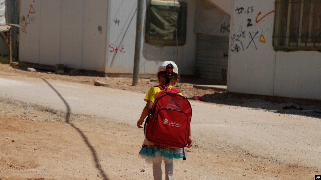 Seorang anak perempuan berjalan ke sekolah di Kamp Pengungsi Zaatari untuk pengunsi Suriah di Yordania bagian utara (foto: AP Photo/Reem Saad)