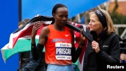 Priscah Jeptoo (kiri) dari Kenya setelah melintasi garis finish dan memenangkan Maraton New York kategori wanita (3/11). (Reuters/Mike Segar)