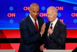 U.S. Senator Cory Booker and former Vice President Joe Biden talk during a commercial break on the second night of the second U.S. 2020 presidential Democratic candidates debate in Detroit, July 31, 2019.