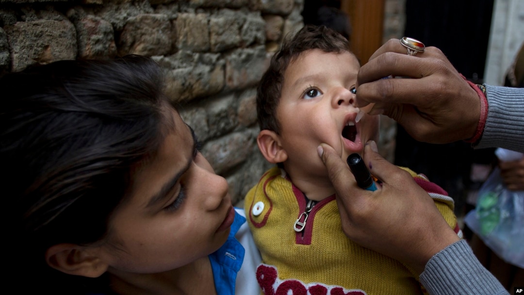 FILE - A Pakistani health worker gives a polio vaccine to a child in Islamabad, Dec. 8, 2014.