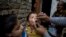 FILE - A Pakistani health worker gives a polio vaccine to a child in Islamabad, Dec. 8, 2014.