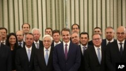 FILE - Greece's new Cabinet pose for the photographers during the swearing in-ceremony at the Presidential Palace in Athens, July 9, 2019. 