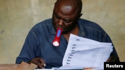 An Independent National Electoral Commission (CENI) official tallies casted votes at the Mavuno polling centre after the end of voting amid the parliamentary and presidential election in Goma, North Kivu province, the Democratic Republic of Congo December 21, 2023.