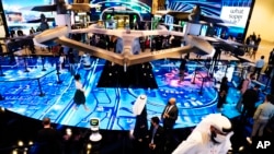FILE - People visit an exhibit at the GITEX technology summit in Dubai, United Arab Emirates, Monday, Dec. 7, 2020.