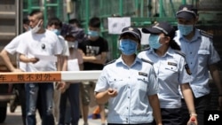 Workers leave from a coronavirus testing center set up outside a sports facility in Beijing, Tuesday, June 16, 2020. China reported several dozen more coronavirus infections Tuesday as it increased testing and lockdown measures in parts of the…