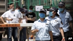 Workers leave from a coronavirus testing center set up outside a sports facility in Beijing, June 16, 2020.