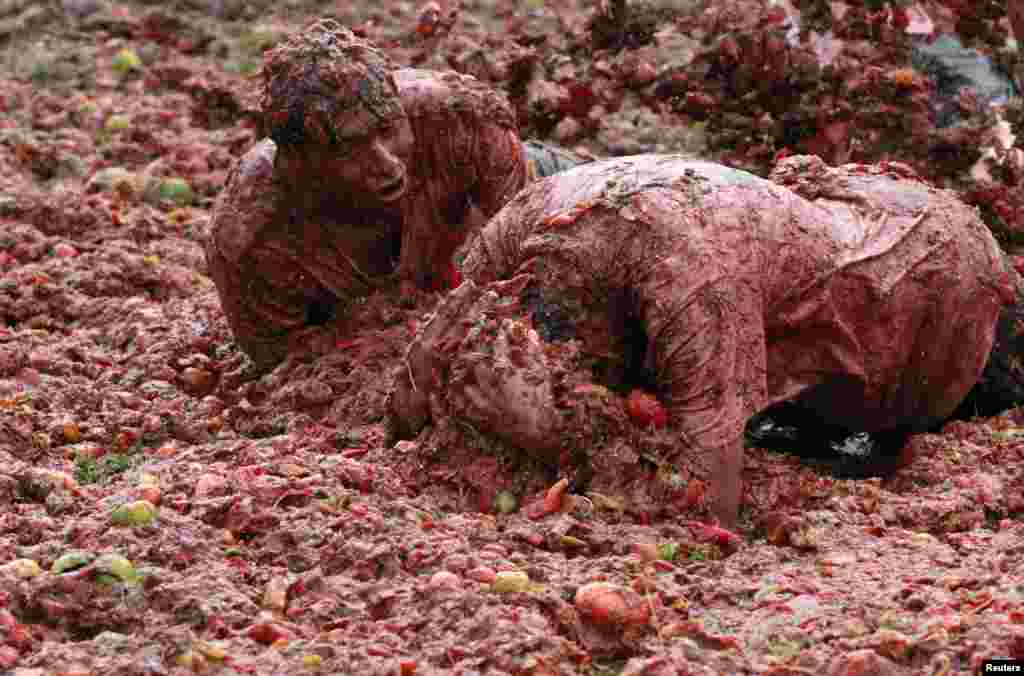 Warga bersuka ria bermain dengan bubur tomat selama acara tradisional tahunan &quot;Tomatina&quot; (perang tomat), di Boyaca, provinsi Sutamarchan, Kolombia.