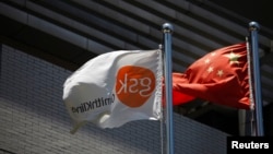 Bendera produsen boat Inggris GlaxoSmithKline (GSK) dan bendera China berkibar di depan kantor GSK di Shanghai (Foto: dok). 