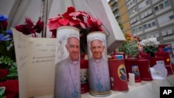 Candles with the pictures of Pope Francis are seen outside Agostino Gemelli Polyclinic in Rome, Feb. 19, 2025, where the pontiff has been hospitalized since Feb. 14.