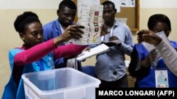 Uma delegada eleitoral mostra um boletim de voto durante a contagem no fim das eleições gerais em Luanda, Angola. 13 de Agosto 2017