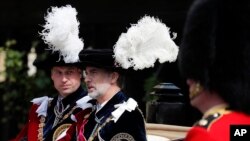 FILE - Britain's Prince William, left, and Spain's King Felipe sit in a carriage after the Order of The Garter Service at Windsor Castle in Windsor, June 17, 2019. 