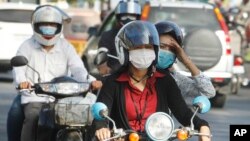 Cambodians wear masks to avoid the contact of coronavirus in Phnom Penh, Cambodia, Tuesday, Jan. 28, 2020. (AP Photo/Heng Sinith