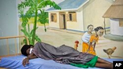 FILE - In this February 27, 2014 photo, a newly-diagnosed HIV positive woman, who arrived at the hospital with symptoms of TB, lies in the treatment ward of the Mildmay Uganda clinic in Kampala, Uganda.