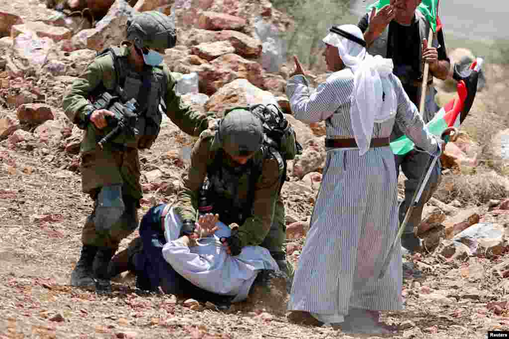 Israeli soldiers detain a Palestinian demonstrator during a protest against Jewish settlements near Tulkarm in the Israeli-occupied West Bank.