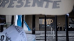 Personal de seguridad custodia una puerta mientras manifestantes protestan frente a la Fiscalía General de la República en la Ciudad de Guatemala, el miércoles 18 de octubre de 2023.