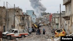 一个伊拉克家庭走在因伊斯兰国进攻而混乱的摩苏尔市(2017年3月4日)