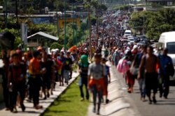 FILE - Central American migrants walk along the highway near the border with Guatemala, as they continue their journey trying to reach the U.S., in Tapachula, Mexico, Oct. 21, 2018.