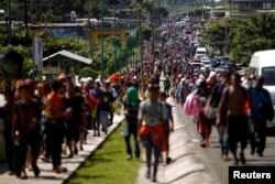 FILE - Central American migrants walk along the highway near the border with Guatemala, as they continue their journey trying to reach the U.S., in Tapachula, Mexico, Oct. 21, 2018.