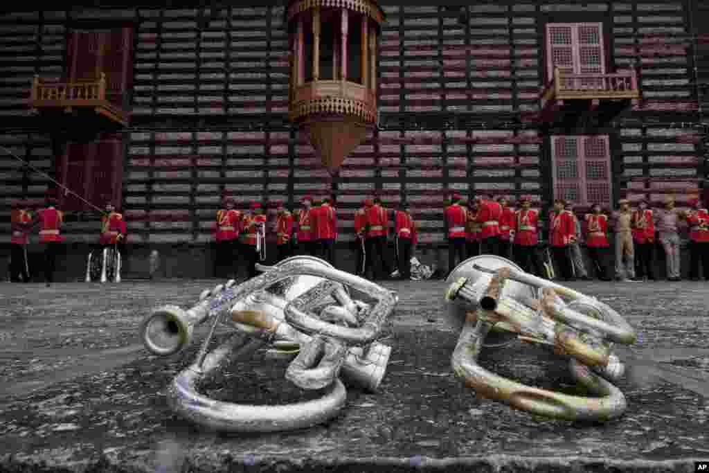 Members of Jammu and Kashmir police band take cover from the rain at a shrine as trumpets are placed on the ground in Srinagar, Indian-controlled Kashmir.