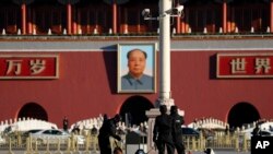 Police officers use sniffer dogs to check on a trash bin on Tiananmen Square. 