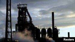 FILE - One of the blast furnaces of the Tata Steel plant is seen at sunset in Port Talbot, South Wales, May 31, 2013. 