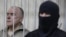 Olexiy Pukach, left, in a defendant's cage on the final day of his trial in Kiev, Ukraine, Jan. 29, 2013.