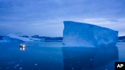 FILE - A boat navigates at night next to large icebergs in eastern Greenland, Aug. 15, 2019. Denmark, in response to U.S. President-elect Donald Trump's remarks on acquiring Greenland, has made it clear that Greenland is not for sale.