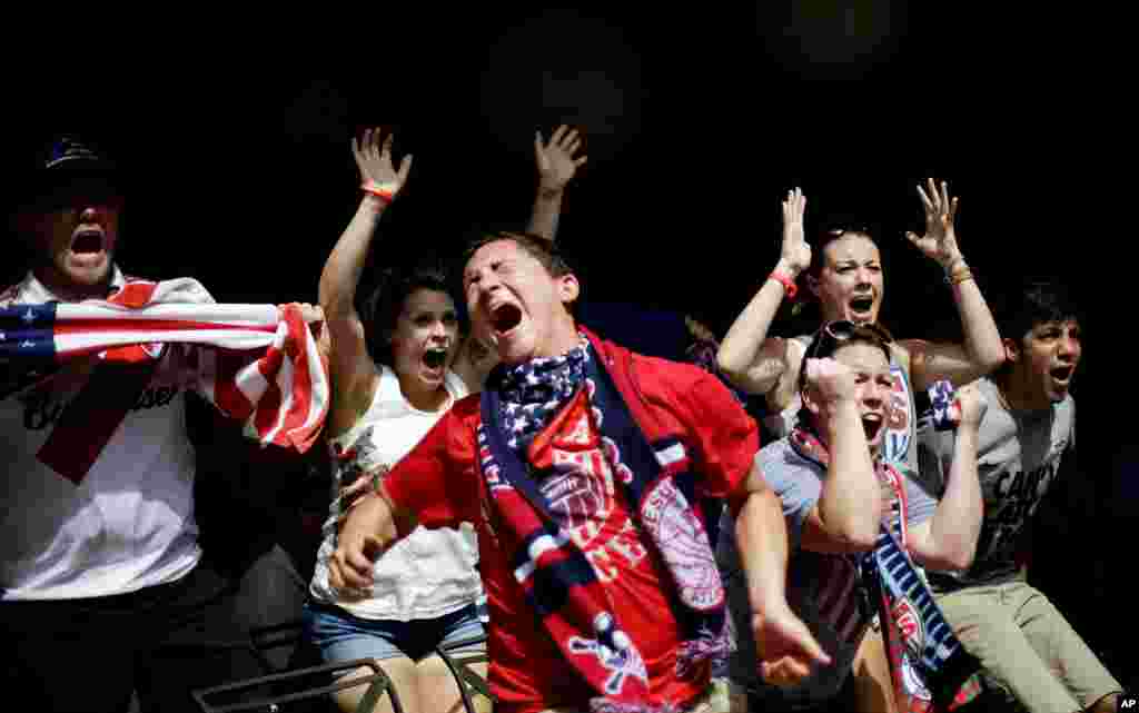 Harrison Heiman, center, and Lindsay Heiman, right, react with fellow fans while watching the 2014 World Cup soccer match between the United States and Belgium at a viewing party in Atlanta, Georgia, USA, July 1, 2014.