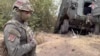 FILE - In this photo taken from video released by the Russian Defense Ministry on Sept. 13, 2024, a Russian soldier stands next to a damaged Ukrainian military vehicle in the Russian-Ukrainian border area in the Kursk region, Russia.