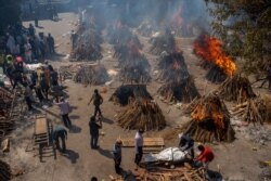 Multiple funeral pyres of COVID-19 victims burn at a site that has been converted into a mass crematorium, in New Delhi, India, April 24, 2021.