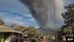 Sejumlah warga di desa Boru, Kabupaten Flores Timur, Provinsi Nusa Tenggara Timur, berupaya menyelamatkan diri saat Gunung Lewotobi Laki-laki meletus kembali pada Selasa, 5 November 2024. (Foto: Arnold Welianto/AFP)