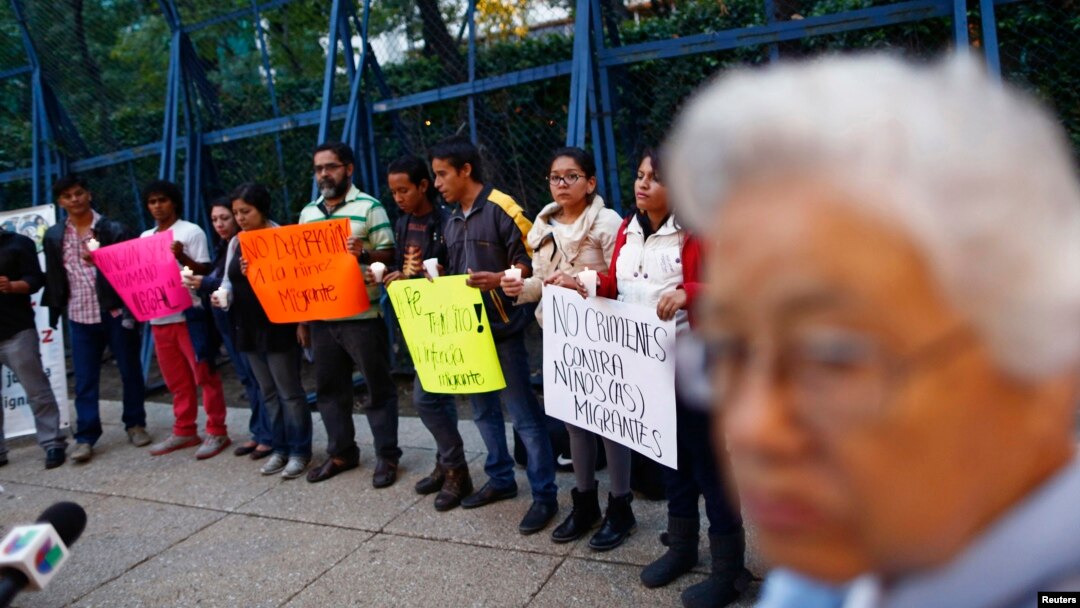 FILE - Migrants from Central America hold candles during a protest demanding a reform in U.S. immigration laws which regulate the illegal exodus of children into the U.S., and to provide protection for them, outside the U.S. embassy in Mexico City.