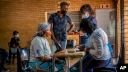 People are processed before receiving their jab against COVID-19 Friday Dec. 3, 2021 at the Orange Farm, South Africa, multipurpose center. (AP Photo/Jerome Delay)