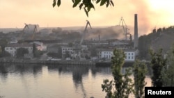 Дым над верфью, которая, как сообщается, подверглась украинскому ракетному обстрелу в Севастополе, Крым, на этом кадре из видео, снятого 13 сентября 2023 года.