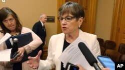 FILE - Kansas Gov. Laura Kelly speaks with reporters at the Statehouse in Topeka, Kansas, June 5, 2019.
