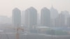 Tampak lokasi pembangunan dekat wilayah gedung-gedung pencakar langit di Beijing, China, dipenuhi oleh polusi udara, pada 11 Maret 2021. (Foto: Reuters)