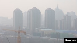 Tampak lokasi pembangunan dekat wilayah gedung-gedung pencakar langit di Beijing, China, dipenuhi oleh polusi udara, pada 11 Maret 2021. (Foto: Reuters)